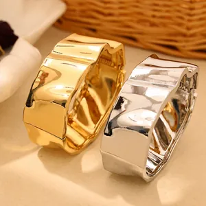 Gros plan de bracelets en alliage à texture irrégulière en finitions dorée et argentée