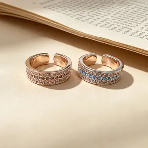 Macro detail of two rose gold open rings featuring three rows of pavé set crystals.