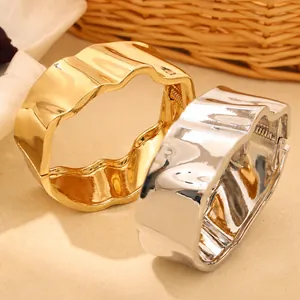 Détail de bracelets jonc ondulés irréguliers en métal or et argent avec ouverture à ressort
