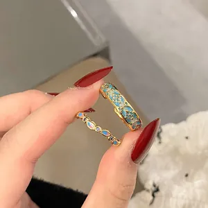 Detail view of vintage gold ring set with gradient blue enamel and colorful stones
