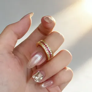 Elegant close-up of a vintage gold band ring with ruby and diamond rows on a manicured hand
