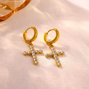 Macro view of elegant gold-plated stainless steel cross earrings with sparkling crystals