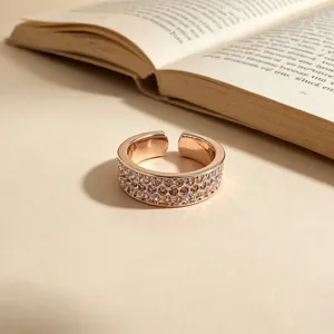 Macro detail of three-row pavé star rose gold open ring with vintage book prop background