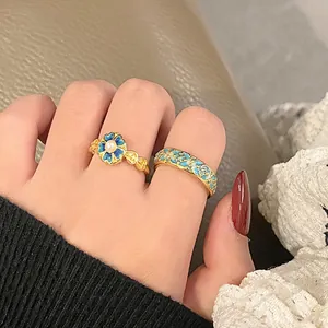 Detailed view of vintage blue gradient floral enamel open rings with pearl center on finger
