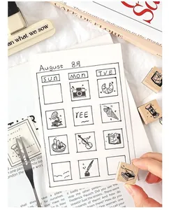 Close-up of cute wooden decorative stamps showing camera and food impressions on a journal.