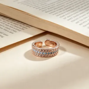 Rose gold adjustable open ring with three rows of sparkling blue stones and crystals.