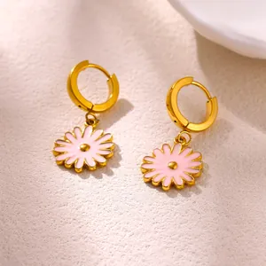 Detailed macro shot of gold-plated stainless steel hoop earrings with pink daisy pendants