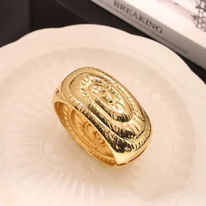Detalle macro de un brazalete de aleación dorado texturizado con apertura de resorte ajustable