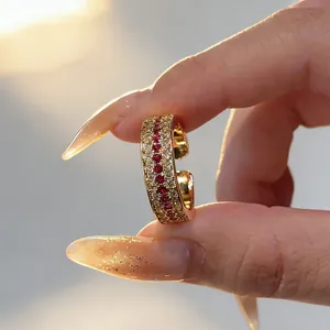 Close-up detail of a vintage gold ring featuring red and white pavé set gemstones