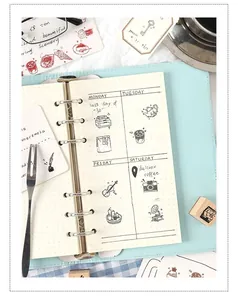 Close-up detail of cute wooden stamp impressions with coffee and camera icons in a journal