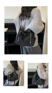 Black textured hobo bag with silver zippers shown from different angles on a model