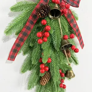 Detail view of festive Christmas swag featuring pine cones, red berries and brass bells
