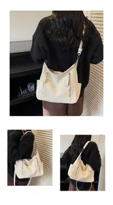 Detail view of a large cream-colored slouchy hobo crossbody bag for daily commuting