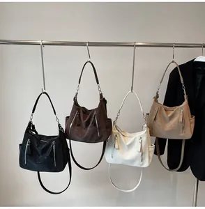 Multiple colors of textured hobo crossbody bags hanging on a display rack for women