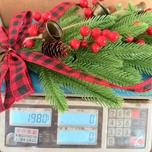 Close-up of Christmas wall hanging garland being weighed on a scale at 198 grams