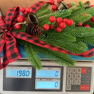 Nahaufnahme einer weihnachtlichen Wandgirlande, die auf einer Waage 198 g wiegt
