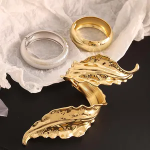 Elegante brazalete de hoja dorada y juego de pulseras de metal con textura plateada