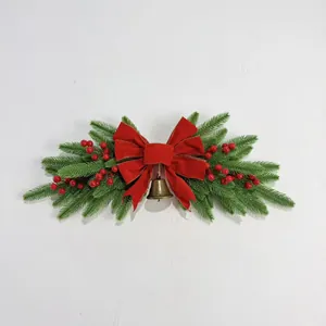 Festive Christmas wall swag with red velvet bow, green pine needles and a bell
