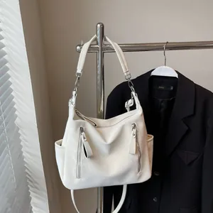 Stylish white hobo shoulder bag with front zipper pockets and adjustable crossbody strap