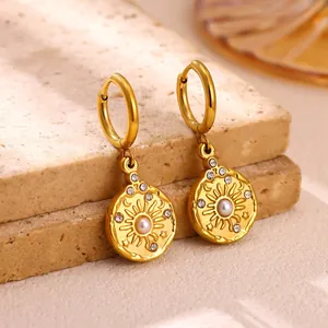 Detailed macro shot of vintage gold sun flower hoop earrings with central pearl and crystals