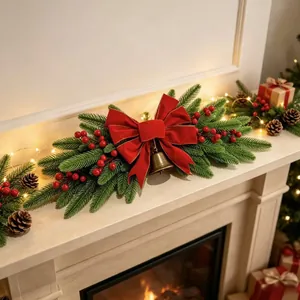 Detailed macro view of a festive Christmas swag with red bow and golden bell decoration.