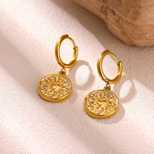 Detail showing gold stainless steel hoop earrings with heart and sunflower charm