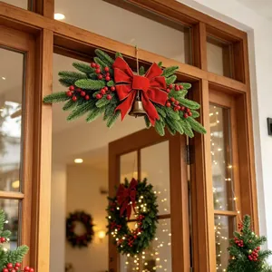 Detail of Christmas door lintel swag with red velvet bow, golden bell, and berries