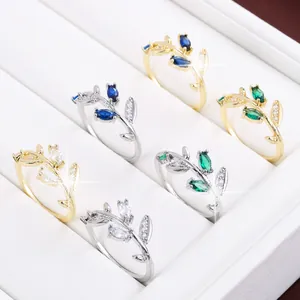 Detailed macro view of leaf branch rings with colorful gemstones in gold and silver plating