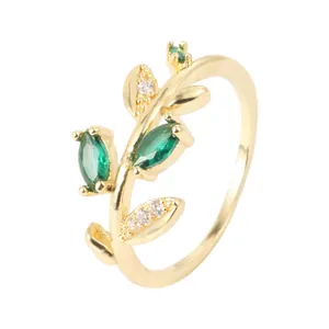 Exquisite close-up detail of a gold leaf ring with marquise-cut emerald green stones