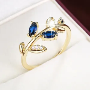 Macro view of a gold-plated branch-shaped ring with marquise-cut blue stones and white gems