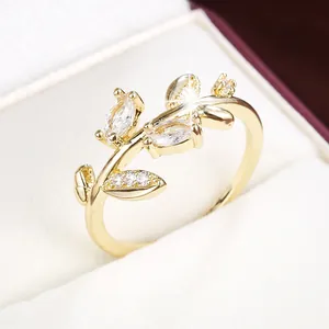 Elegant close-up of a golden branch and leaf ring with sparkling cubic zirconia stones