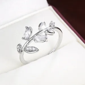 Detailed macro view of an elegant silver branch leaf ring set with sparkling stones