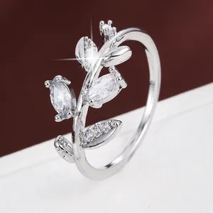 Macro detail showing the exquisite craftsmanship of a silver leaf-shaped ring with crystals