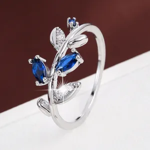 Detailed view of an elegant branch-shaped silver ring featuring blue marquise-cut stones