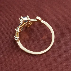 Macro view of a creative leaf-shaped copper ring featuring dark blue stones and gold finish