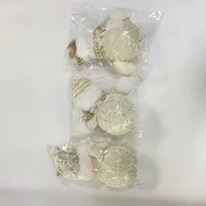 Drie wit gebreide kerstknuffelpoppen individueel verpakt in doorzichtige zakken
