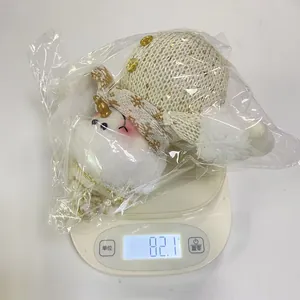Een kerst pluche sneeuwpop op een digitale weegschaal met een gewicht van 82,1 gram.