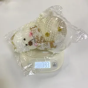 Detailweergave van een kerstsneeuwpop pluche pop met gewichtsmeting van 73,3 g op de schaal