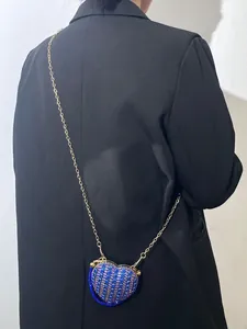 Mini sac à bandoulière en forme de cœur avec strass bleus porté par un mannequin