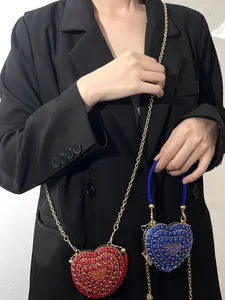 Gros plan sur des mini-sacs étincelants en forme de cœur avec strass rouges et bleus