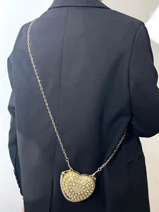 Vue détaillée d'un sac de soirée étincelant en strass en forme de cœur avec chaîne dorée
