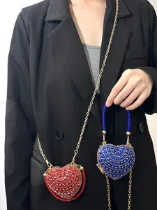 Gros plan de mini sacs de soirée brillants en forme de cœur avec strass et chaînes
