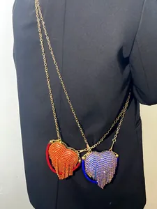 Vue détaillée de sacs de soirée en strass en forme de cœur avec chaînes et glands élégants.