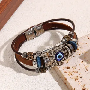 Detailed close-up of a vintage leather multi-layer bracelet with blue Evil Eye charm