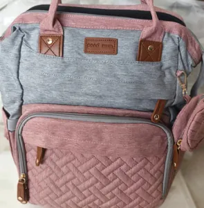 Detail of pink and grey diaper bag with quilted pattern and 'good mum' patch.