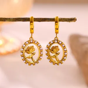 Close-up of gold-plated rose drop earrings with delicate white pearl embellishments