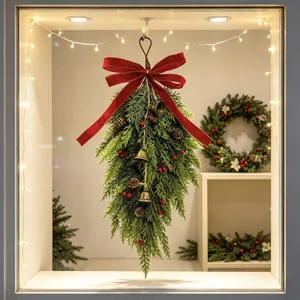 Elegant detailed view of cedar teardrop swag with red velvet bow and vintage bells.