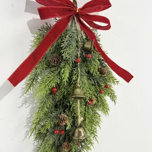 Festive Christmas wall hanging with red velvet bow, bronze bells, and pine cones