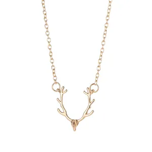 Close-up of gold-toned reindeer antler pendant on a delicate chain for Christmas.