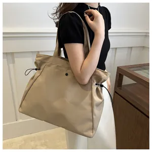 Minimalist large khaki canvas tote bag shown on shoulder for casual and stylish commuting